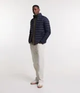 Campera puffer ultraligera de cuello alto con cierre frontal por cremallera y bolsillos laterales. Diseño acolchado con acabado liso.