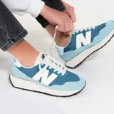Championes New Balance 237 de mujer, color celeste con detalles en blanco y suela color crema.
