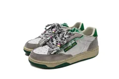 Zapatillas casual Arizona Love con base color beige, puntera blanca y detalles de tela estampada con motivos de leopardo y flores. Cordones gruesos rojos con cuentas de colores.