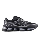 Championes urbanos New Balance modelo 2000, color negro con detalles en gris plateado. Presentan una estructura de malla transpirable con refuerzos sintéticos, cierre de cordones y una suela con tecnología de amortiguación visible.