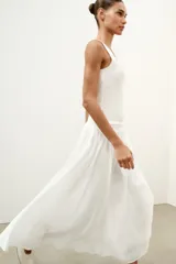 Top de punto canalé en color beige, con escote en pico adornado con una delicada aplicación de encaje blanco y tirantes anchos.
