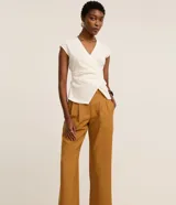 Pantalón de sastrería corte recto confeccionado en crepé, con pliegues delanteros y cintura con detalle cruzado. Presenta un diseño estructurado y elegante.