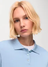 Jersey de punto fino en mezcla de algodón y lana, color celeste, con cuello polo y cierre frontal de botones.