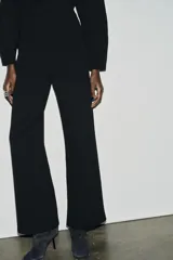 Pantalón de tiro alto con corte ancho y recto, confeccionado en tejido de punto elástico y flexible con cintura elástica.