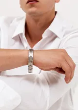 Pulsera de acero quirúrgico plateado con eslabones rectangulares y circulares.