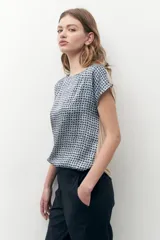 Blusa beige con estampado geométrico, cuello redondo y mangas cortas.