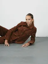 Campera verde militar de pana con cuello camisero, cierre frontal con botones a tono, dos bolsillos de parche con solapa en el pecho y corte cropped.