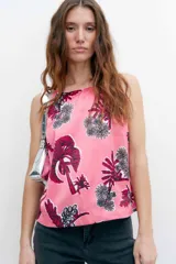 Top rosado con estampado de palmeras y flores, con escote halter y espalda descubierta.