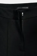 Leggings negros de tiro alto con costura marcada en el frente y bajo acampanado (flare). Cierre frontal con cremallera, botón interior y gancho.