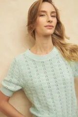 Top tramado color crudo, de manga corta, cuello redondo y elástico en la cintura y mangas.