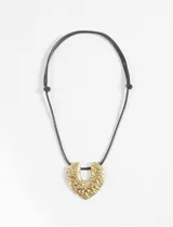 Collar con cordón negro ajustable y dije dorado con textura irregular.