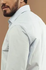 Camisa de vestir de manga larga en color blanco, con cuello clásico y cierre frontal de botones.