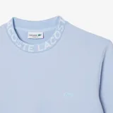 Buzo Lacoste celeste de corte clásico, confeccionado en algodón orgánico y poliéster reciclado. Presenta cuello redondo con inscripción de la marca y logo de cocodrilo en el pecho.