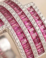 Anillo de plata 925 con diseño de bandas cruzadas, engastado con circonias blancas y circonias fucsia en corte baguette.