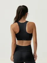 Top deportivo verde con cremallera frontal, de sujeción alta y tejido Shape_Tech con tecnología Performance.