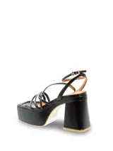 Sandalia de cuero negra con tiras finas y ajuste en el talón. Tiene punta cuadrada y tacón alto forrado en el mismo material.