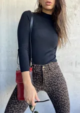 Polera negra de tejido de punto acanalado, manga larga y cuello alto.