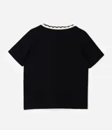 Blusa de manga corta confeccionada en viscolycra, con escote en V y detalle de cuello con borde ondulado en contraste. Presenta un diseño amplio con aberturas laterales en el ruedo.