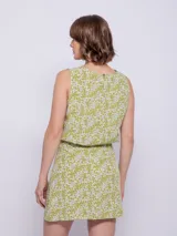 Falda corta con estampado floral en tonos verde lima y blanco, con cintura elástica y corte asimétrico en el ruedo.