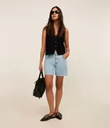 Short de jean celeste, con cintura media, trabillas, cierre con botón y cremallera, y bolsillos delanteros y traseros.