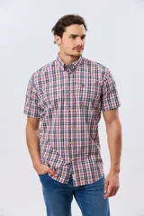 Camisa de manga corta con estampado de cuadros en tonos azules, rojos y blancos, cuello con botones y bolsillo ojal en el pecho con logo bordado.