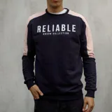 Buzo negro con mangas color rosa pálido y texto estampado en blanco que dice 'Reliable Duxon Collection'.