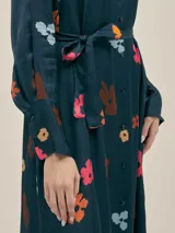 Vestido largo estilo camisero confeccionado en seda viscosa con estampado abstracto en blanco y negro. Cuenta con botones nacarados, bolsillos laterales, lazo para ajustar en la cintura y aberturas laterales.