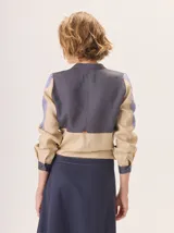 Camisa de algodón con diseño de bloques de color en tonos marrón, rosa y lila. Presenta cuello redondo, cierre frontal con botones y mangas largas.