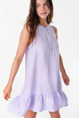 Vestido corto lila de lino, sin mangas, con escote redondo, cartera de botones de nácar en el frente y volado fruncido en el ruedo.