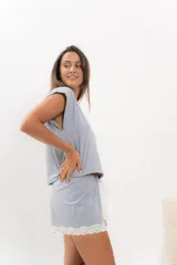 Pijama celeste de algodón con textura acanalada, compuesto por una remera de mangas cortas con escote en V y puntilla blanca, y un short con elástico en la cintura, lazo y terminación con puntilla.