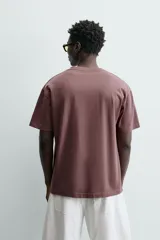 Camiseta color arena de algodón compacto, corte recto, cuello redondo y mangas cortas.