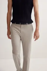 Pantalón de vestir color beige, corte slim fit, con pliegues, bolsillos laterales y traseros ribeteados con botón.