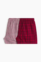 Pack de dos calzoncillos tipo boxer en tejido suave, con cintura elástica y bragueta de botones. Uno de ellos presenta un patrón a cuadros pequeños en tonos rojo y blanco, mientras que el otro cuenta con un diseño de cuadros tipo tartán en tonos rojo y negro.