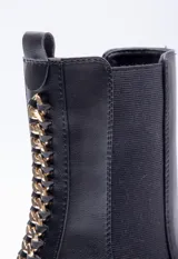 Bota de caña media color marrón con pieza elastizada en los laterales, detalle metálico atrás y plataforma de 6cm de alto.