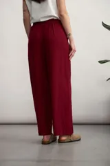 Pantalón palazzo color bordó, de tiro alto con cintura elástica fruncida y cordón ajustable del mismo tono. Cuenta con bolsillos laterales tipo parche.