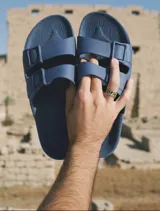 Sandalias planas color ladrillo, con doble tira ancha sobre el empeine y plantilla anatómica. Fabricadas en Brasil con materiales veganos y procesos sostenibles.