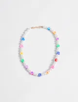 Collar corto con perlas sintéticas, mostacillas y flores de colores. Incluye cadena de extensión.