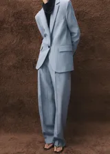 Blazer de corte sastre en color celeste con estampado de raya diplomática, cuello de solapa con muesca, cierre frontal de un botón, bolsillos con solapa en los laterales y bolsillo de ribete en el pecho.