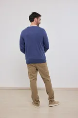 Suéter de punto color azul marino con cuello en V y manga larga. Se lleva sobre una remera blanca con cuello en V.