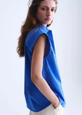Camisa de popelín color azul, de diseño oversize y sin mangas, con cuello camisero, bolsillo parche delantero y cierre frontal con botones.