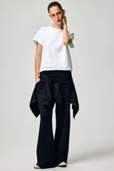 Pantalón de corte holgado en punto pesado con leve brillo, color negro. Modelo con elástico revestido en la cintura, bolsillos al bies y piernas rectas con pliegues cosidos.