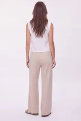 Babucha de calce relajado color beige, confeccionada en tejido de algodón con cintura elastizada, cordón de ajuste, bolsillos laterales y pernera amplia de estilo urbano.