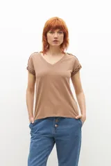 Remera color marrón con cuello en V y detalle de trenzas en los hombros.