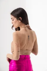 Top negro brillante con escote halter y espalda descubierta.