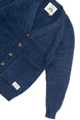 Cardigan azul de lana merino con cuello en V, cierre con botones marrones y dos bolsillos frontales.