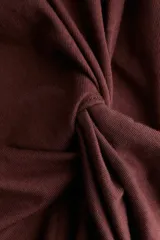 Remera de punto suave de algodón, color marrón, con cuello redondo, mangas cortas y detalle girado en un lateral que crea un efecto drapeado.