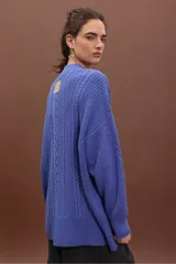Sweater de punto negro con diseño de trenzas verticales, cuello alto y corte holgado de estilo oversize.
