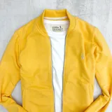 Campera bomber amarilla con cierre frontal y logo bordado en el pecho.