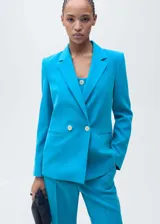 Chaqueta tipo blazer de corte recto en color turquesa, con cuello de solapa, cierre frontal de doble botonadura y manga larga. Cuenta con forro interior.