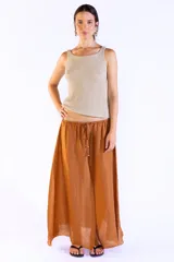 Musculosa sin mangas tejida en punto canalé con mezcla de viscosa e hilos metálicos Lurex, de color dorado. Presenta escote bote y calce cómodo al cuerpo.